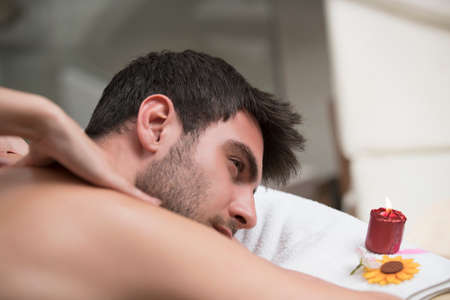 Sports massage. Massage therapist massaging shoulders of a male athlete, working with Trapezius muscle.の写真素材