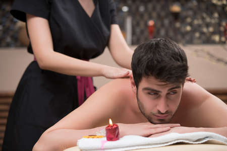 Sports massage. Massage therapist massaging shoulders of a male athlete, working with Trapezius muscle.の写真素材