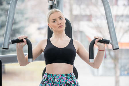 Beautiful woman in the gym exercise backの写真素材