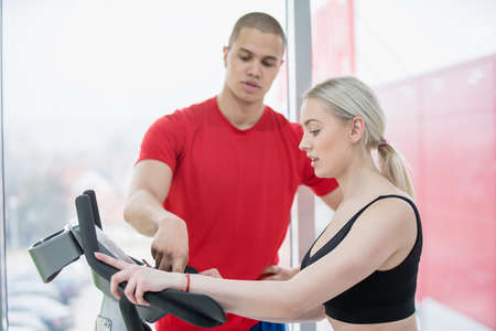 Fitness couple running doing cardio on treamill in fitness center gymの写真素材