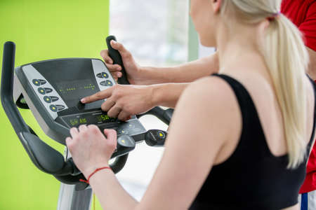 Fitness couple running doing cardio on treamill in fitness center gymの写真素材