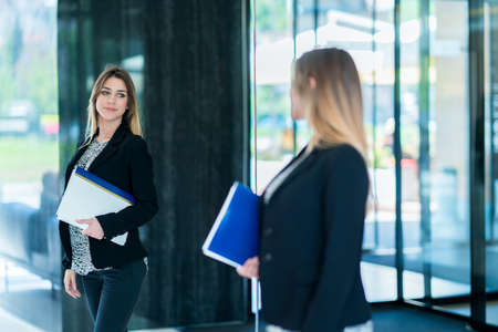 Handsome confident business woman holding files. Portrait of a handsome CEO. Handsome executive business woman at the workspace officeの写真素材