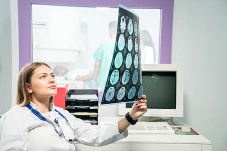 Female doctor looking at an x-ray in her officeの写真素材