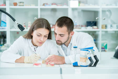Young team of dental technicians making teeth prostetics. Process of making denture.の写真素材
