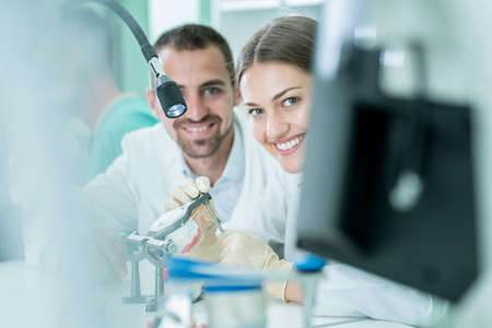 Young team of dental technicians making teeth prostetics. Process of making denture.の写真素材
