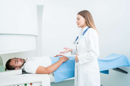 Beautiful female doctor visiting male patient who is in bed.の写真素材