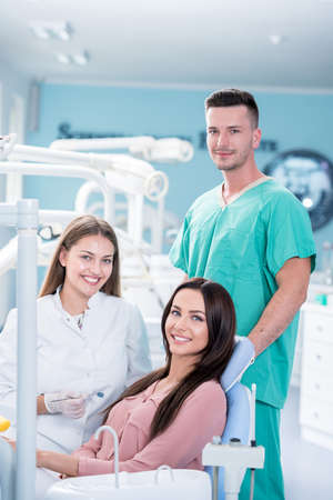Female dentist, female patient and assistent smiling after checkup.の写真素材