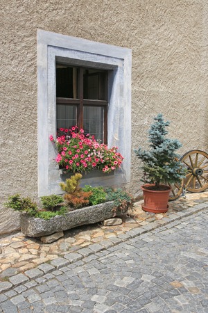 Detail of traditional window decorated with flowers at the stone pavementの写真素材