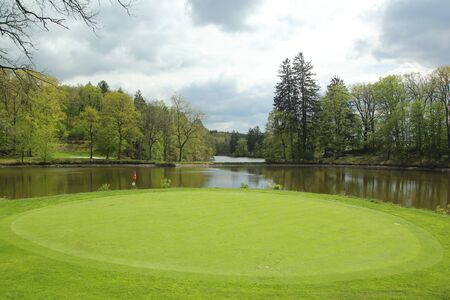 View of golf course, circle part with surrounded by waterの写真素材