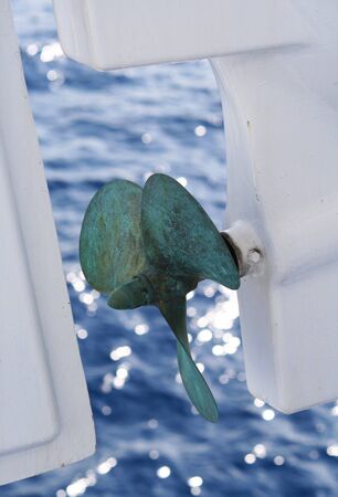 Green ship screw above the water surface, sun reflectionの写真素材