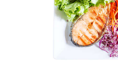 Isolated salmon steak on white dish and vegetableの写真素材