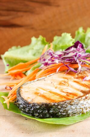 vertical veiw of salmon steak and vegetable on woodの写真素材