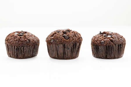 Three abreast of chocolate muffins on white background with clipping pathの写真素材