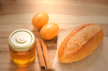 bread , honey and eggs on wooden table