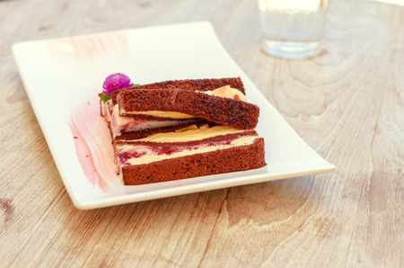 selective focus on chocolate ice cream roll on white plate on wooden table in warm light