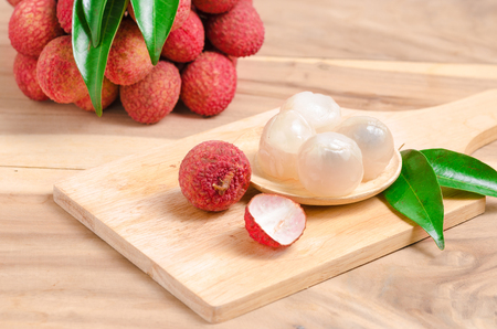 peeled lychee and leaves on wooden tableの写真素材