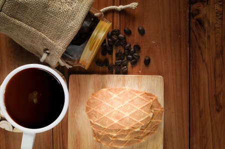 coffee and butter crisps on wooden table and coffee seed in glass bottlesの写真素材