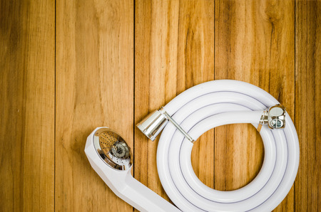 shower head and plastic water pipe put on woodの写真素材