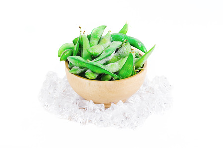 Frozen edamame or soybean surround with ice on white with clipping path, it is a cuisine of Japan, China and Asianの写真素材