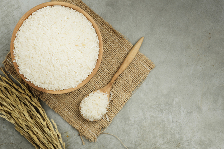 top view of rice in wooden bowl on concrete texture with copy spaceの写真素材