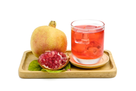 glass of pomegranate juice and its fruit put on wooden tray on white with clipping pathの写真素材