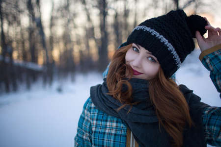 Red-haired girl with make-up in the woods in winterの写真素材
