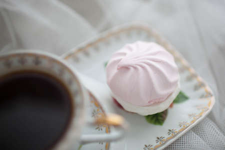 Cup of black tea on white fabric. Marshmallows next to the tea. Breakfast Bridesmaid.の写真素材