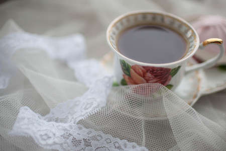 Cup of black tea on white fabric. Marshmallows next to the tea. Breakfast Bridesmaid.の写真素材