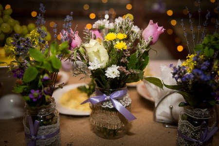 Decorative fresh bouquets of roses and wildflowers in designer bottles. Handmade.の写真素材