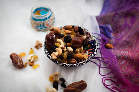 plate with nuts and dried fruits lying on a white tableの写真素材