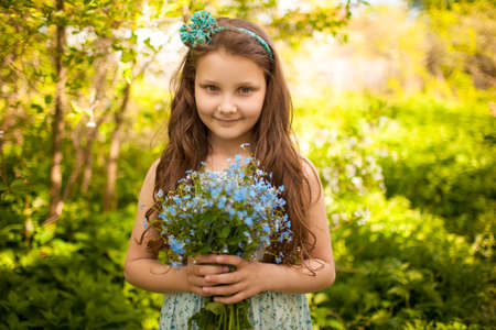 Girl with a bouquet of wild blue flowersの写真素材
