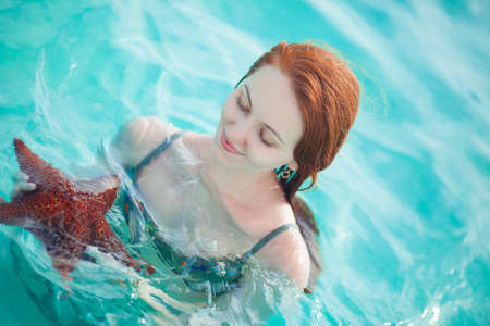Young woman holding a starfishの写真素材