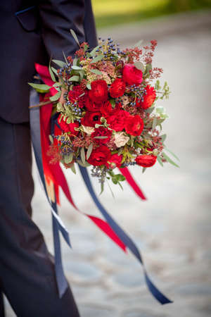 The man is holding a gorgeous bouquet of rosesの写真素材