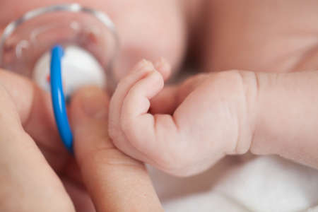 Hand the sleeping baby in the hand of mother close-up.の写真素材