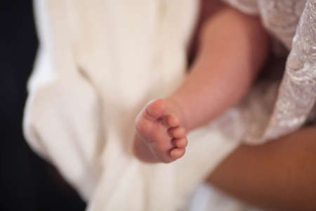 Feet of baby close up. Childish legs on blurred background.