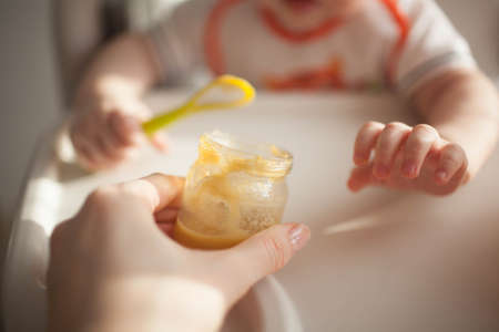 Baby 6 months old and he for the first time tries vegetable squashの写真素材