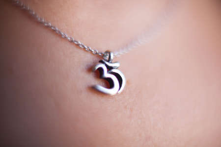 Om symbol medallion around the neck of a woman.の写真素材