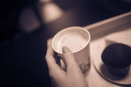 Womans hand holding a Cup of coffee.の写真素材