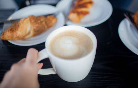 Cup of double espresso coffee with piece of cake on wooden table. Close upの写真素材