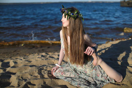 Young healthy woman practicing yoga on the beach at sunrise.の写真素材