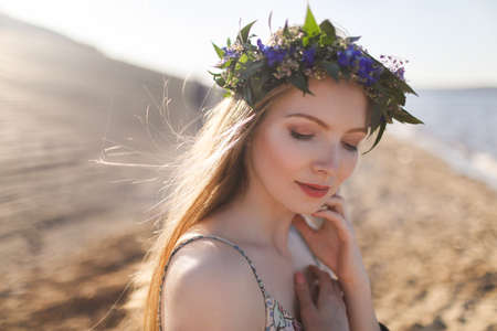 Beautiful Model Woman with Perfect Makeup, Long Curly Hair and Wreath of Flowersの写真素材