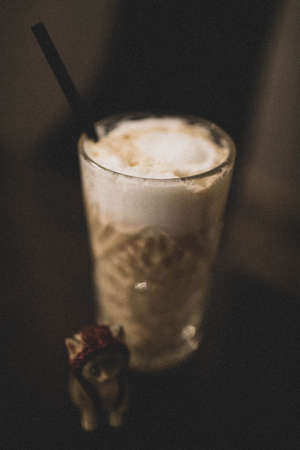 Latte in a clear glass with a strawの写真素材