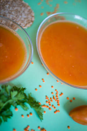 Spicy red lentil soup in a copper pot on a wooden table, close-upの写真素材