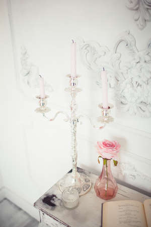 A lot of candles with candlesticks on the home background. Home and home decor. Candles flame. HOME...