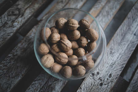 Walnut kernels and whole walnuts on rustic old oak table.Walnuts in a shellの写真素材