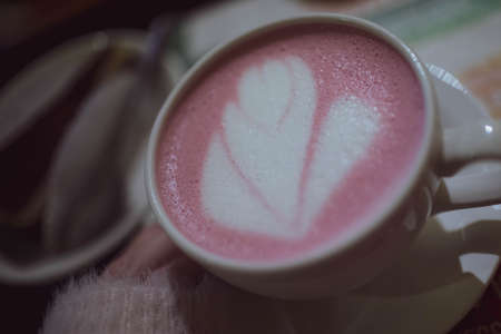 Pink tea matcha in a white mug on the table in a cafe. Close up.の写真素材