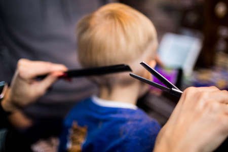 A little boy in the Barber shop at the hairdressers.の写真素材