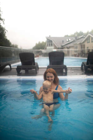 Mom and child in the pool relax and swim.Mom and child in the pool relax and swim.