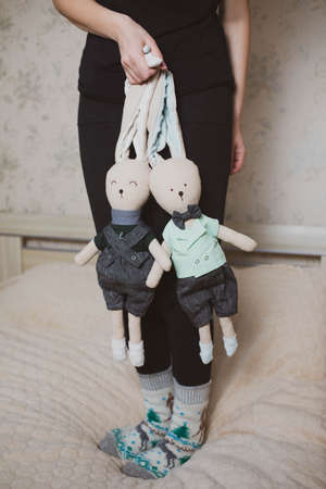 Soft toys two hares handmade in the hands of a woman.の写真素材
