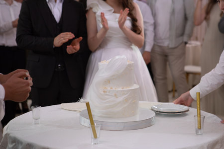 Cake with white cream, decorated with gold confectionery sprinkles on a white background. Two-tiered white cake.の写真素材